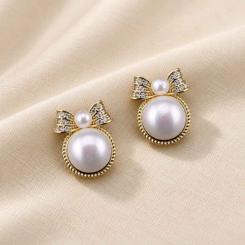 VEEKISSY bow freshwater pearl stud earrings, alternative pair angle on cream fabric
