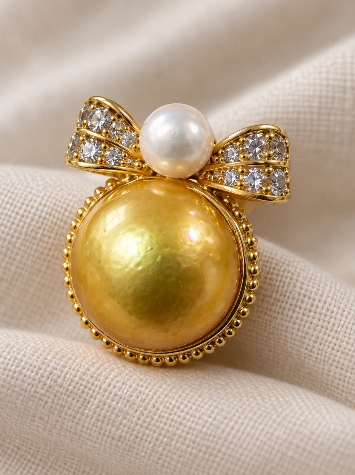 Close-up of the golden pearl, white pearl and sparkling bow details